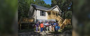 SCOR team standing in front of the last completed home from the 2015 floods
