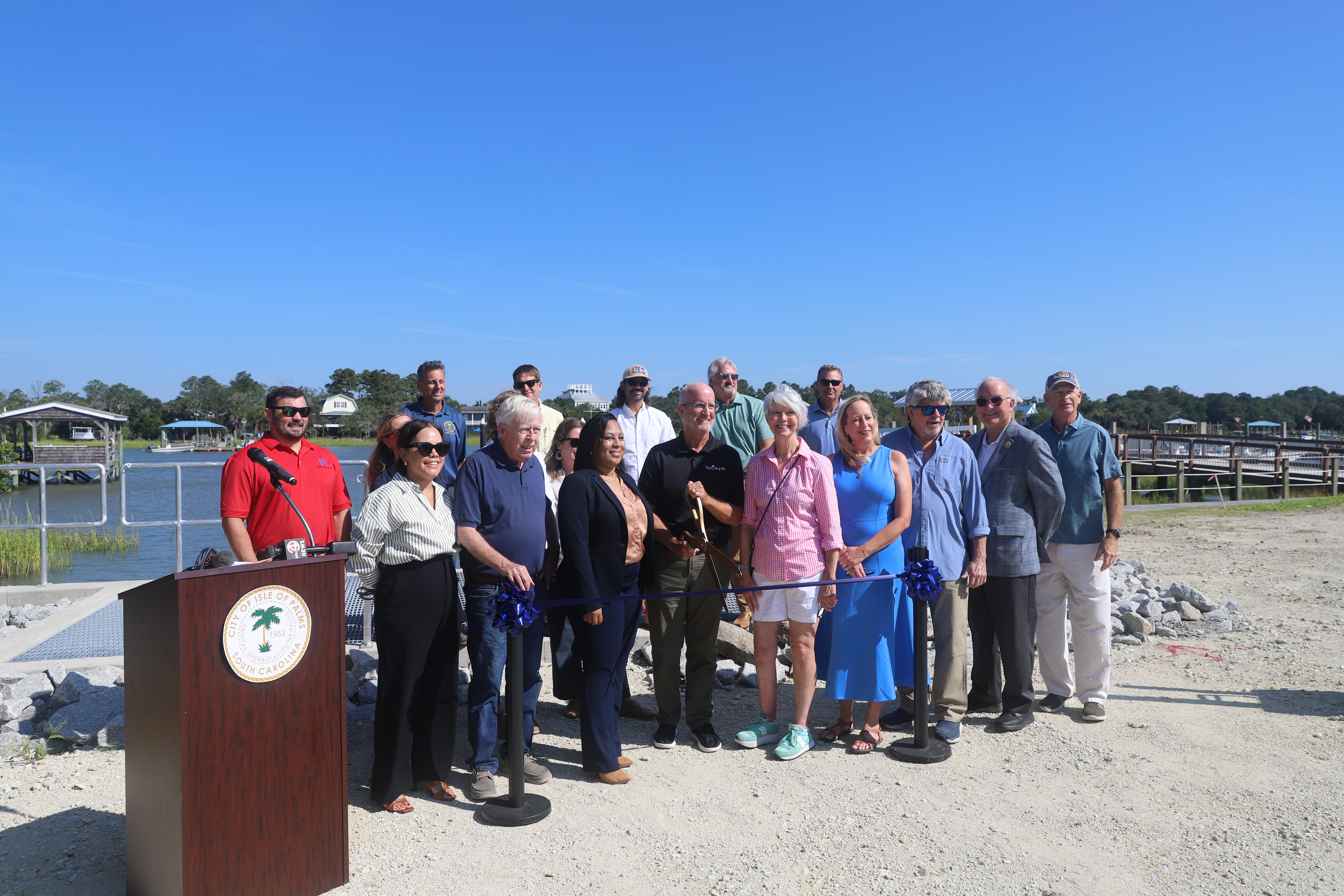 A group of people pose at a ribbon cutting ceremony