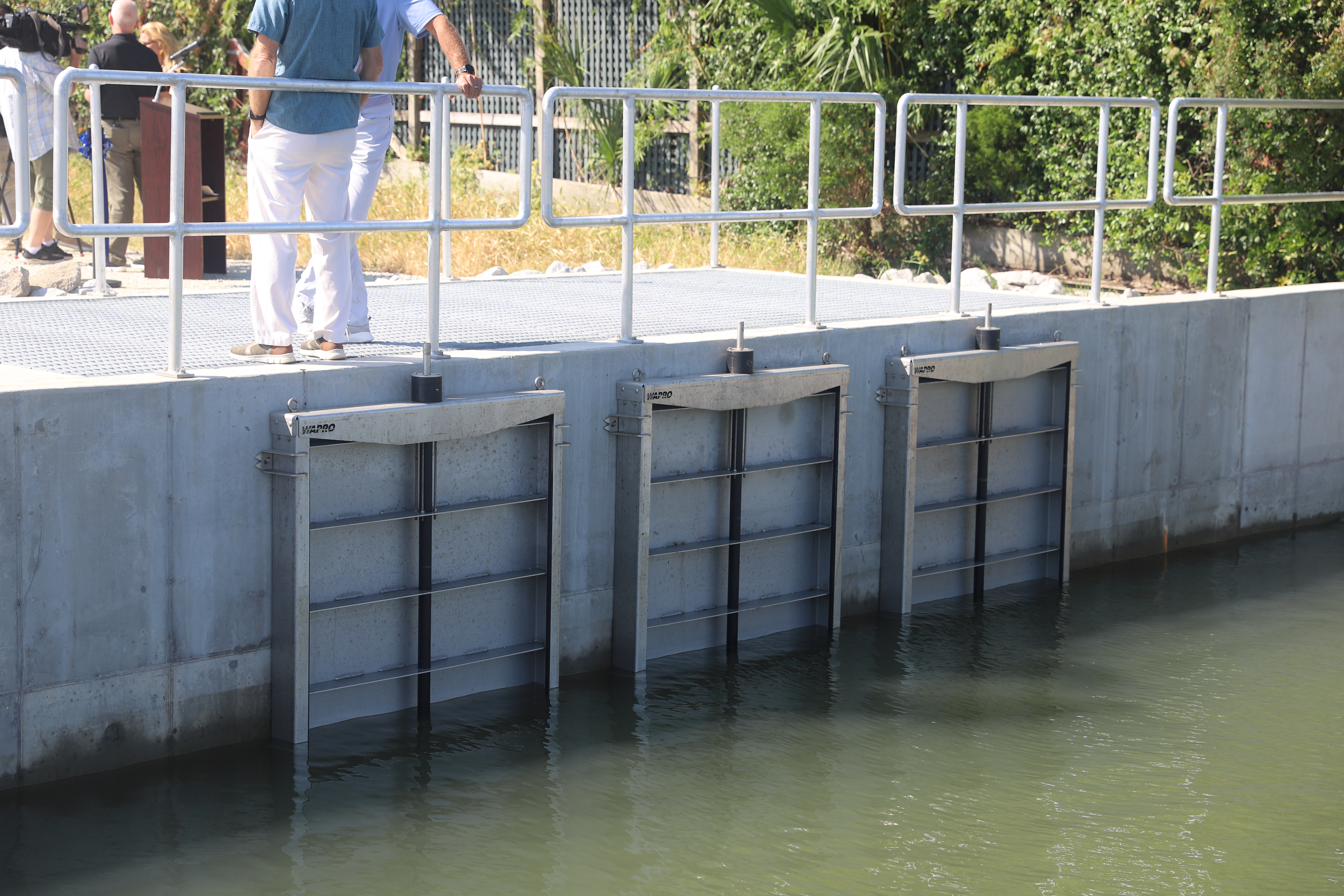 A new drainage outfall with three check valves photographed facing inland.