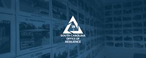 Photographs of repaired and rebuilt houses hanging on a conference room wall with the SC Office of Resilience logo overlayed